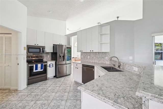 5708 NW 47th Ct, Coral Springs, FL 33067 - kitchen featuring stainless steel appliances, open shelves, a sink, backsplash, and a peninsula