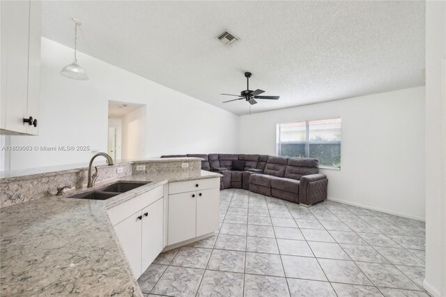 5708 NW 47th Ct, Coral Springs, FL 33067 - kitchen featuring a sink, ceiling fan, white cabinetry, light stone countertops, and a textured ceiling