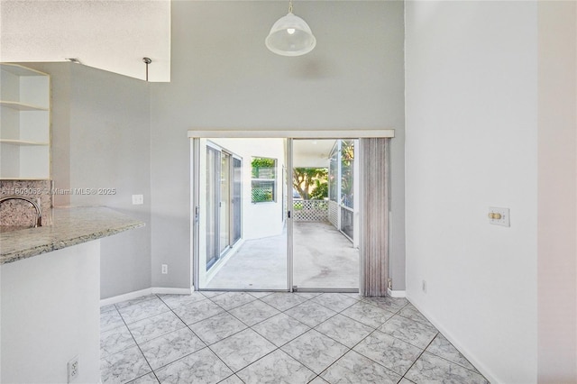 5708 NW 47th Ct, Coral Springs, FL 33067 - unfurnished dining area featuring a towering ceiling, baseboards, a sink, and light marble finish floors