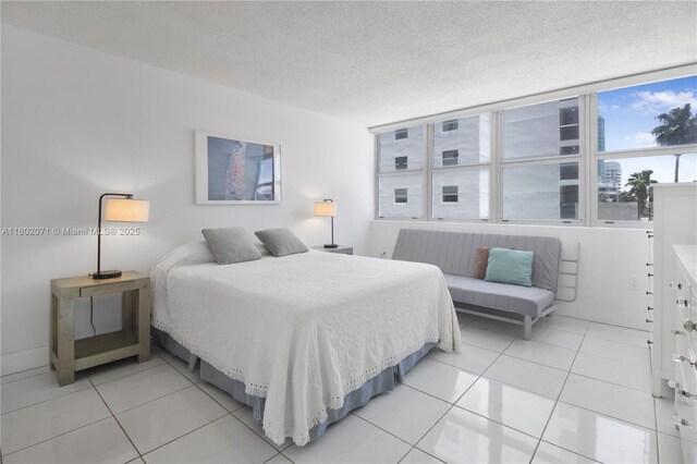 5838 Collins Ave Unit 2H, Miami Beach, FL 33140 - bedroom featuring light tile patterned floors and a textured ceiling