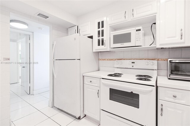 5838 Collins Ave Unit 2H, Miami Beach, FL 33140 - kitchen with white appliances, light countertops, white cabinets, and light tile patterned floors