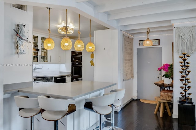 1601 S Ocean Dr Unit 106, Hollywood, FL 33019 - kitchen with a kitchen bar, dark wood-type flooring, beam ceiling, glass insert cabinets, and pendant lighting