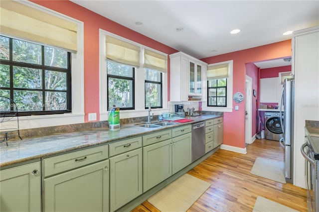 515 Gulf Blvd, Indian Rocks Beach, FL 33785 - kitchen featuring green cabinets, appliances with stainless steel finishes, a sink, washer / clothes dryer, and light wood finished floors