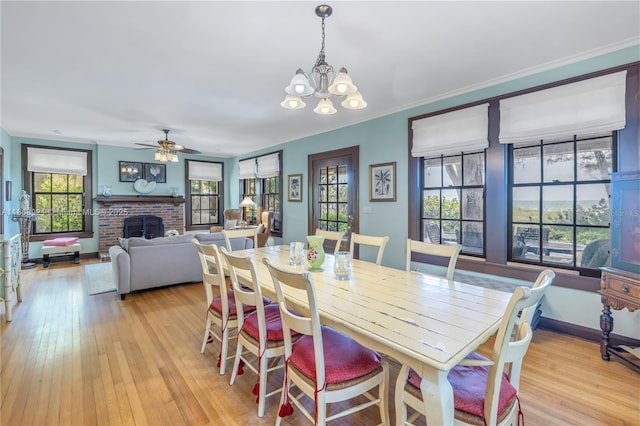515 Gulf Blvd, Indian Rocks Beach, FL 33785 - dining room featuring plenty of natural light, a fireplace, light wood finished floors, ceiling fan, and crown molding