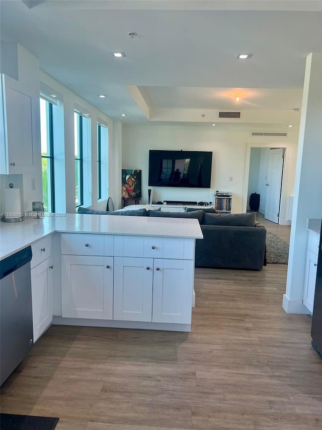 4100 SW 64th Ave Unit 201, Davie, FL 33314 - kitchen with dishwasher, white cabinets, a peninsula, light countertops, and light wood-style flooring