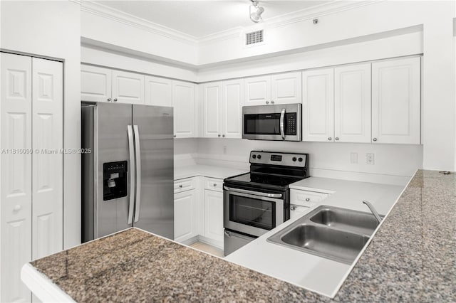 6851 SW 44th St Unit 109, Miami, FL 33155 - kitchen with stainless steel appliances, ornamental molding, white cabinetry, and a peninsula