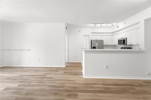 6851 SW 44th St Unit 109, Miami, FL 33155 - kitchen with stainless steel appliances, white cabinetry, a peninsula, light wood-type flooring, and a textured ceiling
