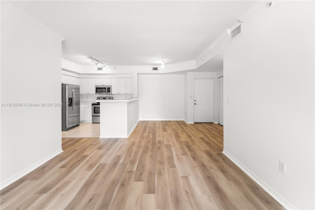 6851 SW 44th St Unit 109, Miami, FL 33155 - kitchen with appliances with stainless steel finishes, ornamental molding, light countertops, white cabinetry, and light wood-style floors