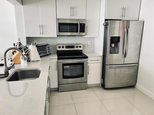 2780 NE 183rd St Unit 1110, Aventura, FL 33160 - kitchen featuring appliances with stainless steel finishes, a sink, white cabinetry, and backsplash