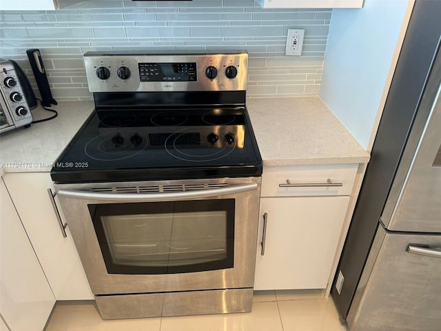 2780 NE 183rd St Unit 1110, Aventura, FL 33160 - kitchen with appliances with stainless steel finishes, tasteful backsplash, light countertops, and white cabinetry
