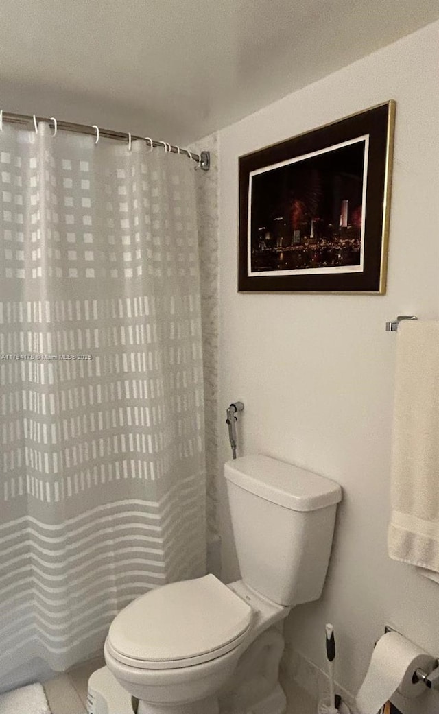 2780 NE 183rd St Unit 1110, Aventura, FL 33160 - bathroom featuring toilet, curtained shower, and tile patterned flooring