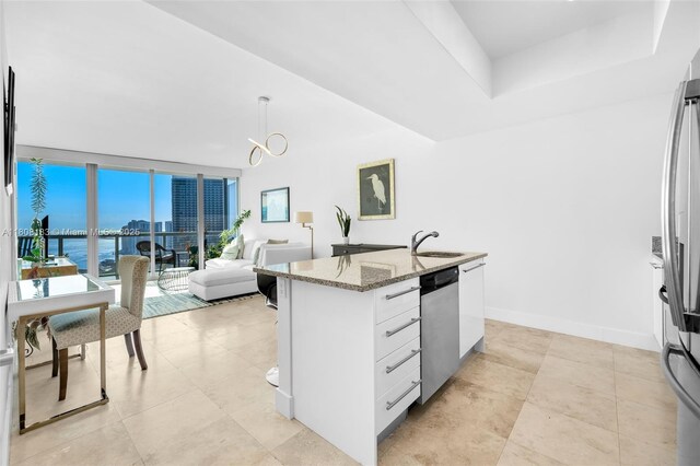 888 Biscayne Blvd Unit 3702, Miami, FL 33132 - kitchen featuring appliances with stainless steel finishes, light stone counters, a sink, open floor plan, and white cabinets