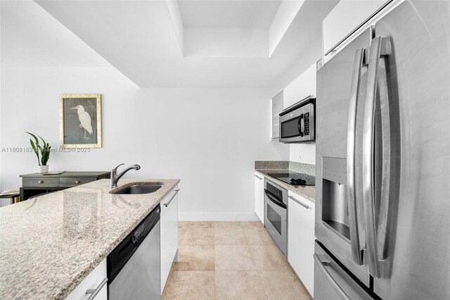 888 Biscayne Blvd Unit 3702, Miami, FL 33132 - kitchen with appliances with stainless steel finishes, a sink, a tray ceiling, white cabinets, and light stone countertops