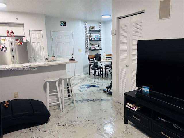 11040 SW 196th St Unit 209, Cutler Bay, FL 33157 - kitchen with freestanding refrigerator, a kitchen breakfast bar, concrete floors, baseboards, and a sink