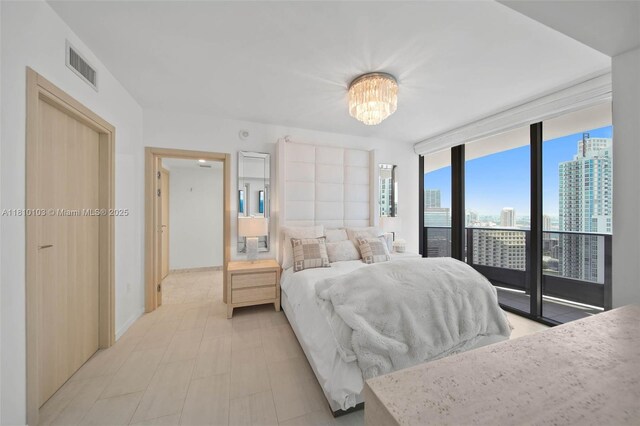 1000 Brickell Plz Unit 4209, Miami, FL 33131 - bedroom with access to outside, a chandelier, a view of city, floor to ceiling windows, and baseboards