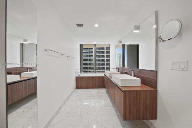 1000 Brickell Plz Unit 4209, Miami, FL 33131 - full bathroom featuring marble tiled flooring, baseboards, two vanities, and recessed lighting