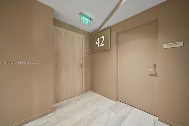 1000 Brickell Plz Unit 4209, Miami, FL 33131 - hallway with lofted ceiling, baseboards, and light marble finish floors
