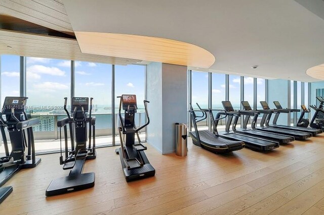 1000 Brickell Plz Unit 4209, Miami, FL 33131 - gym featuring expansive windows, healthy amount of natural light, and hardwood / wood-style floors