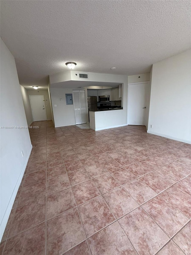 8911 Collins Ave Unit 1103, Surfside, FL 33154 - unfurnished living room with a textured ceiling and tile patterned flooring
