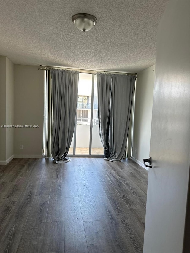 8911 Collins Ave Unit 1103, Surfside, FL 33154 - spare room with a textured ceiling, wood finished floors, and a wall of windows