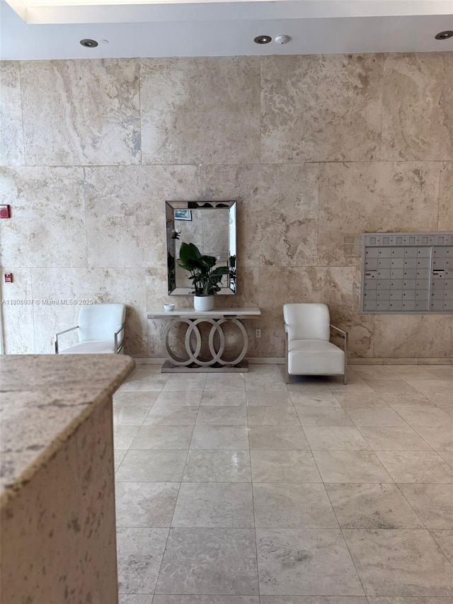 8911 Collins Ave Unit 1103, Surfside, FL 33154 - unfurnished living room featuring mail area, tile walls, and recessed lighting