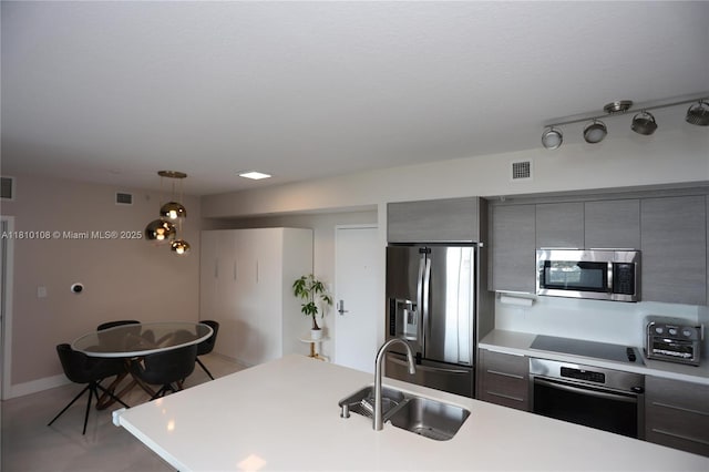 325 S Biscayne Blvd Unit 1822, Miami, FL 33131 - kitchen with stainless steel appliances, a sink, gray cabinetry, hanging light fixtures, and light countertops