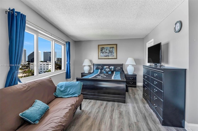 720 Bayshore Dr Unit 804, Fort Lauderdale, FL 33304 - bedroom featuring a textured ceiling, wood finished floors, a skyline view, and baseboards