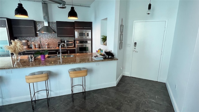 700 NE 25th St Unit 1703, Miami, FL 33137 - kitchen with appliances with stainless steel finishes, a kitchen breakfast bar, dark stone countertops, a sink, and decorative backsplash