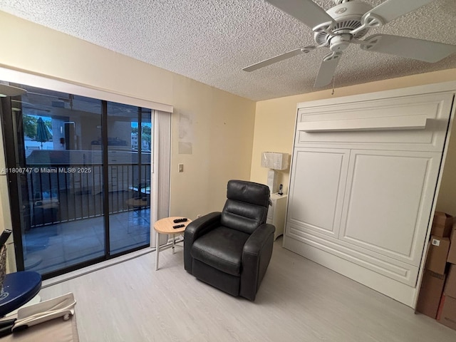 7443 Fairfax Dr Unit 208, Tamarac, FL 33321 - living area with light wood-style floors, a textured ceiling, and ceiling fan