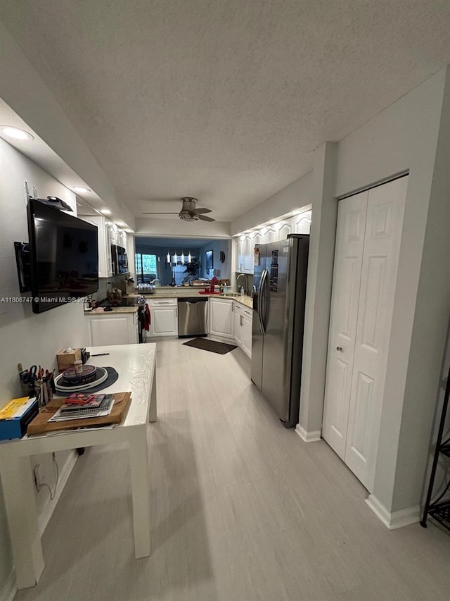 7443 Fairfax Dr Unit 208, Tamarac, FL 33321 - kitchen featuring black appliances, white cabinets, light wood finished floors, a textured ceiling, and a ceiling fan