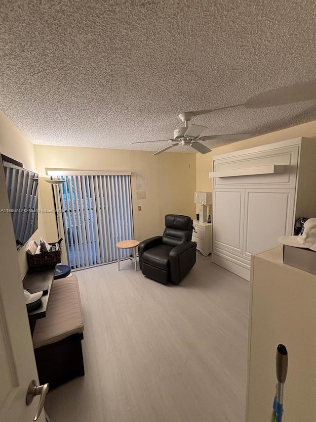 7443 Fairfax Dr Unit 208, Tamarac, FL 33321 - living area with light wood-style flooring, a textured ceiling, and ceiling fan