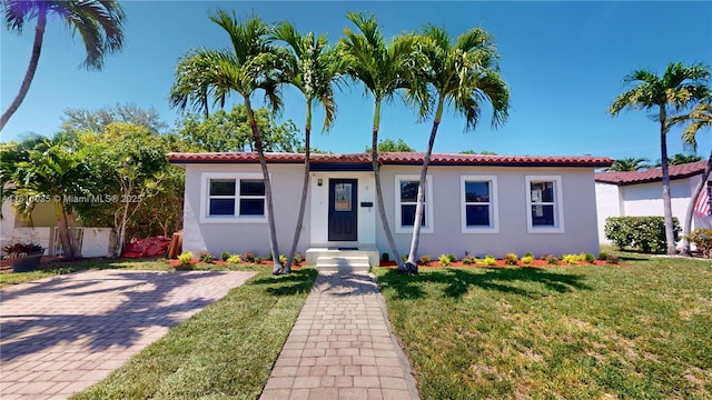 7 Montilla Ave, Coral Gables, FL 33134 - view of front of home featuring a front yard, stucco siding, and a tile roof