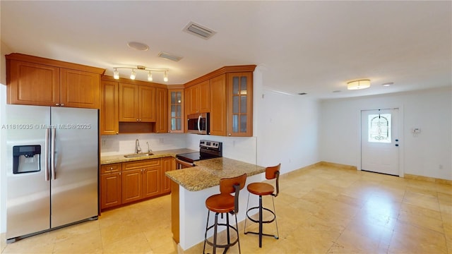 7 Montilla Ave, Coral Gables, FL 33134 - kitchen with appliances with stainless steel finishes, a sink, and brown cabinetry