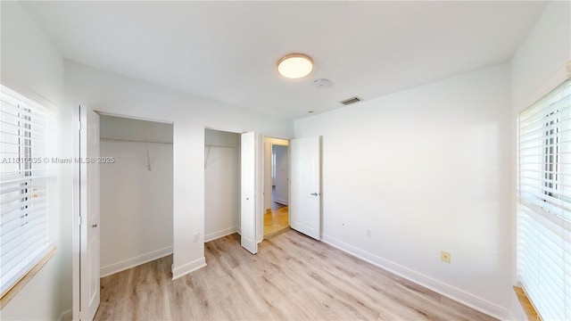 7 Montilla Ave, Coral Gables, FL 33134 - unfurnished bedroom with light wood-type flooring, multiple closets, and baseboards