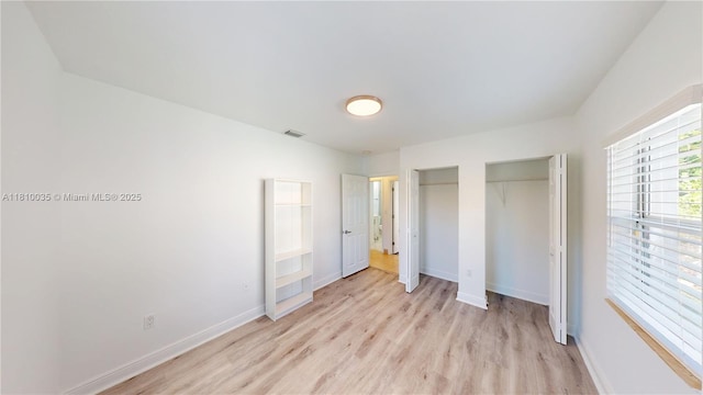 7 Montilla Ave, Coral Gables, FL 33134 - unfurnished bedroom featuring light wood-style floors, two closets, and baseboards