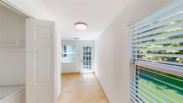 7 Montilla Ave, Coral Gables, FL 33134 - corridor with light tile patterned flooring, baseboards, and washing machine and dryer