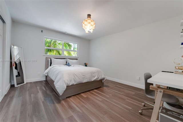 8005 SW 106th St, Miami, FL 33156 - bedroom with wood finished floors, baseboards, and a chandelier