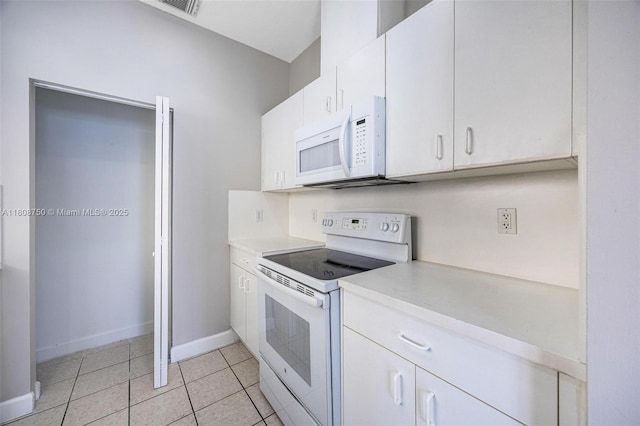 1005 NE 41st Ave, Homestead, FL 33033 - kitchen featuring white appliances, light countertops, white cabinets, light tile patterned floors, and baseboards