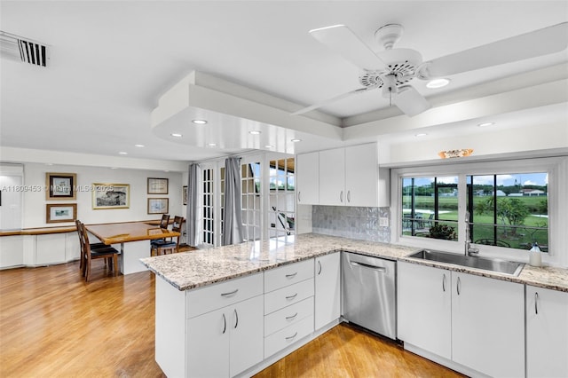 7619 SW 102nd Pl, Miami, FL 33173 - kitchen featuring dishwasher, a peninsula, white cabinetry, light wood-style floors, and tasteful backsplash