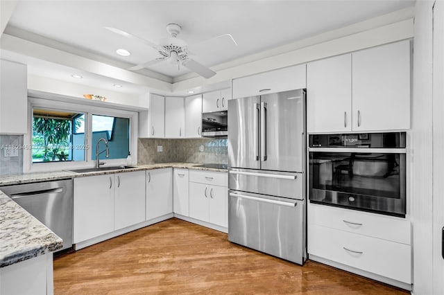 7619 SW 102nd Pl, Miami, FL 33173 - kitchen with stainless steel appliances, a sink, a ceiling fan, white cabinets, and light stone counters
