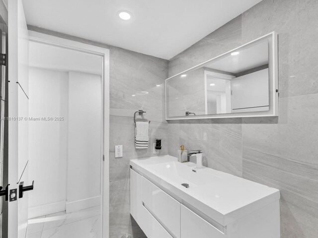 1890 W 56th St Unit 1307, Hialeah, FL 33012 - bathroom featuring tile walls, vanity, recessed lighting, and marble finish flooring