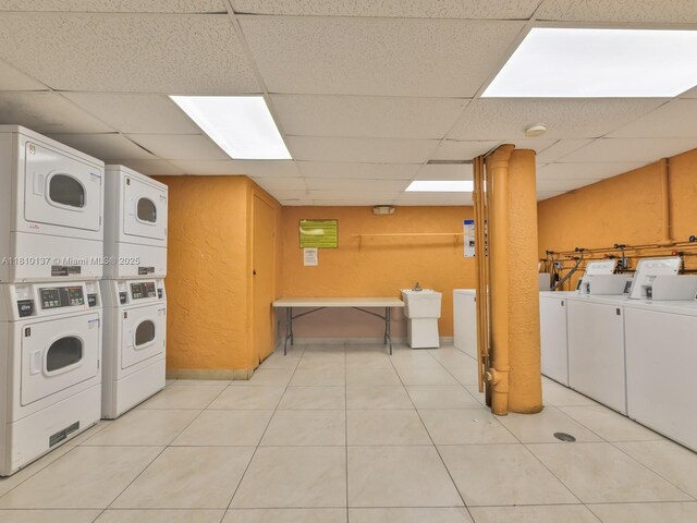1890 W 56th St Unit 1307, Hialeah, FL 33012 - communal laundry room featuring stacked washing machine and dryer, a textured wall, washer and clothes dryer, and light tile patterned flooring