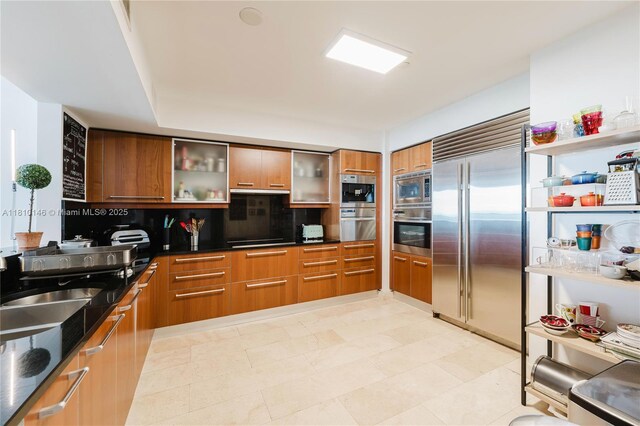 1331 Brickell Bay Dr Unit 2805, Miami, FL 33131 - kitchen with built in appliances, modern cabinets, backsplash, and brown cabinetry