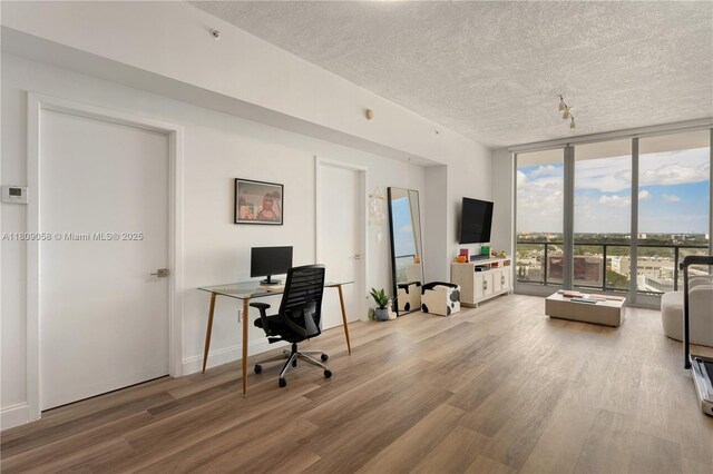 3470 E Coast Ave Unit H1402, Miami, FL 33137 - home office with floor to ceiling windows, a textured ceiling, and wood finished floors