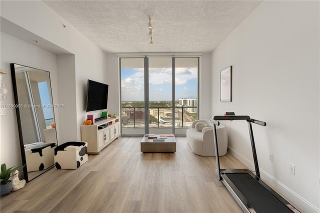 3470 E Coast Ave Unit H1402, Miami, FL 33137 - exercise room with floor to ceiling windows, light wood finished floors, a textured ceiling, baseboards, and track lighting