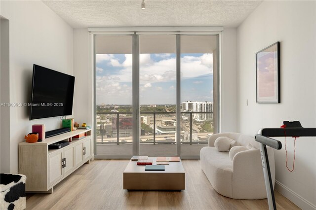 3470 E Coast Ave Unit H1402, Miami, FL 33137 - living room with floor to ceiling windows, light wood-style flooring, and a textured ceiling