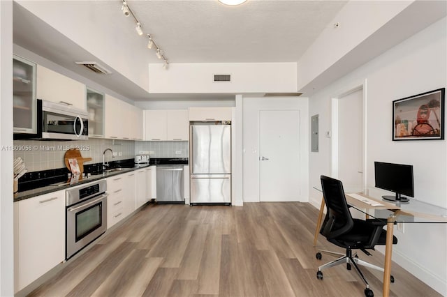 3470 E Coast Ave Unit H1402, Miami, FL 33137 - kitchen with stainless steel appliances, dark countertops, a sink, white cabinetry, and backsplash
