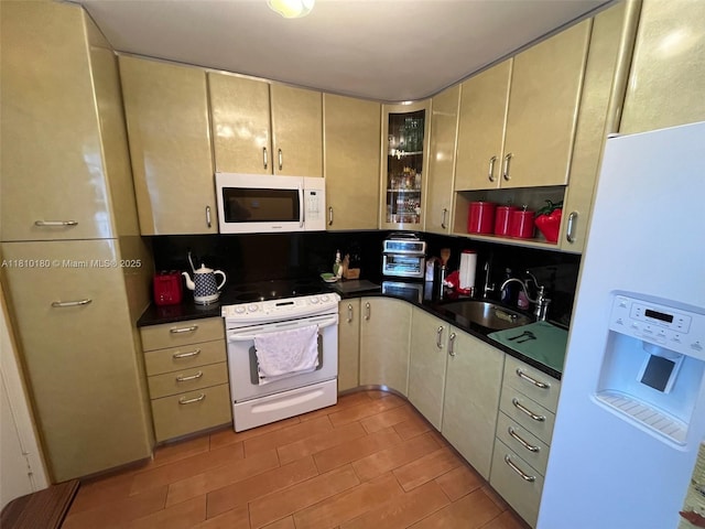 3551 NE 169th St Unit 301, North Miami Beach, FL 33160 - kitchen with white appliances, a sink, dark countertops, and cream cabinets