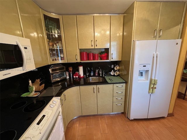 3551 NE 169th St Unit 301, North Miami Beach, FL 33160 - kitchen with white appliances, light wood-style floors, dark countertops, glass insert cabinets, and open shelves