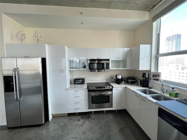 133 NE 2nd Ave Unit 913, Miami, FL 33132 - kitchen featuring stainless steel appliances, white cabinetry, a sink, light countertops, and concrete flooring